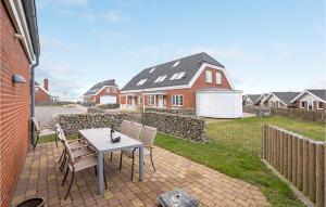 a patio with a table and chairs and a house at Cozy Home In Rm With House Sea View in Rømø Kirkeby