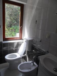 uma casa de banho com um WC e uma janela em Mar Eva Apartment em Rab