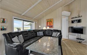 スナーヴィグにあるBeautiful Home In Ringkbing With Wifiのリビングルーム(黒い革張りのソファ、テーブル付)