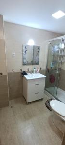a bathroom with a sink and a shower and a toilet at Gran apartamento cerca del mar y Castillo in Denia