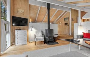 ÅlbækにあるBeautiful Home In lbk With 3 Bedrooms, Sauna And Wifiのリビングルーム(薪ストーブ、ソファ付)