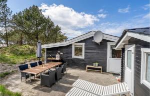 a black house with a patio with a table and chairs at Stunning Home In Thisted With 3 Bedrooms in Sønder Vorupør