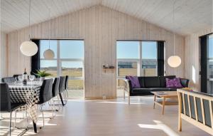 a living room with a table and chairs at 5 Bedroom Pet Friendly Home In Løkken in Løkken