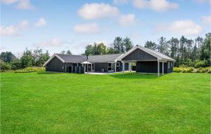 a black house with a large green lawn at Beautiful Home In Jerup With Sauna, Private Swimming Pool And Indoor Swimming Pool in Jerup