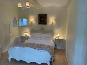 um quarto com uma cama branca com duas mesas de cabeceira em Bri22 -lanvallay - La Petite Madeleine em Dinan