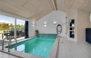 a swimming pool in a house with a table and chairs at Beautiful Home In Jerup With Sauna, Private Swimming Pool And Indoor Swimming Pool in Jerup
