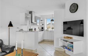 a kitchen with white cabinets and a clock on the wall at Three-Bedroom Holiday Home In Romo in Havneby