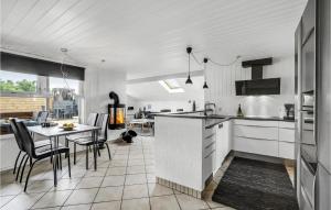 a kitchen and dining room with a table and chairs at 3 Bedroom Nice Home In Thisted in Nørre Vorupør