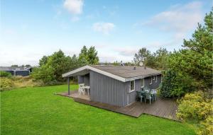 a small gray house with a deck in a yard at Awesome Home In Thisted With 4 Bedrooms in Nørre Vorupør