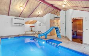 JerupにあるAmazing Home In Jerup With Sauna, Wifi And Indoor Swimming Poolの家屋内の滑り台付きスイミングプール