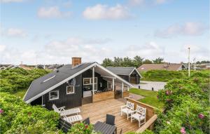a black house with a deck and chairs at 3 Bedroom Nice Home In Thisted in Nørre Vorupør