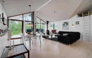 a living room with a black couch and a table at Three-Bedroom Holiday Home In Albak in Ålbæk