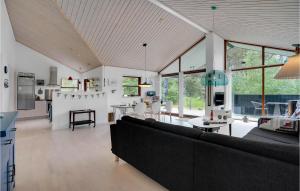 a living room with a large couch and a kitchen at Three-Bedroom Holiday Home In Albak in Ålbæk