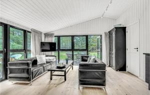 a living room with a couch and a table at Amazing Home In lbk With 3 Bedrooms, Sauna And Wifi in Ålbæk