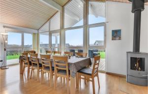 a dining room with a table and chairs and a fireplace at Holiday Home Kildebakken Vinderup V in Vinderup
