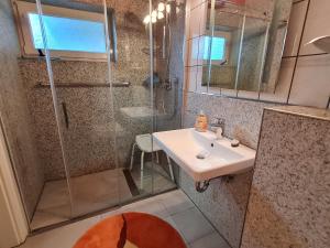 a bathroom with a glass shower and a sink at Ferienhaus Frähmke in Wyk auf Föhr +13 photos