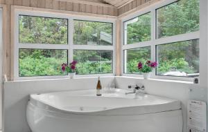 a white bathroom with a sink and four windows at Cozy Home In Jerup With Kitchen in Jerup