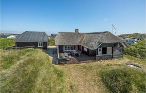 a small house with a thatched roof on a field at 3 Bedroom Pet Friendly Home In Hvide Sande in Hvide Sande