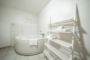 La salle de bains blanche est pourvue d'une baignoire et d'un lavabo. dans l'établissement Villa Borgo B&B, à Motovun