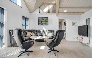 a living room with a couch and a table and chairs at Stunning Home In Harboøre With Sauna in Harboør