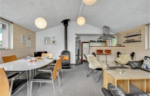 sala de estar con mesa, sillas y chimenea en Awesome Home In Haderslev With Kitchen, en Diernæs