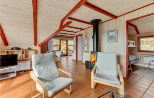 a living room with two chairs and a fireplace at Beautiful Home In Hvide Sande With 3 Bedrooms And Sauna in Havrvig
