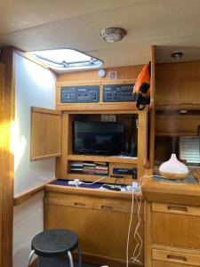 a small kitchen with wooden cabinets and a tv at Luxury boat in Chertsey