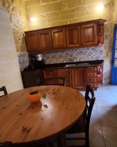 a wooden table in a kitchen with an orange bowl on it at Ta lucia farmhouse with private pool and BBQ in Santa Luċija