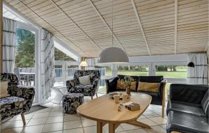 a living room with a table and chairs at Awesome Home In Jerup With 4 Bedrooms, Sauna And Wifi in Jerup