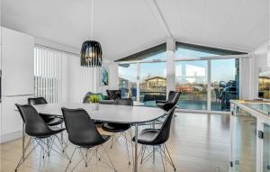 フレデリクスハウンにあるAmazing Home In Frederikshavn With 3 Bedrooms And Wifiのダイニングルーム(テーブル、黒い椅子付)