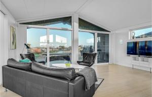 フレデリクスハウンにあるAmazing Home In Frederikshavn With 3 Bedrooms And Wifiのリビングルーム(ソファ、テーブル付)