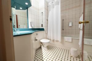 a bathroom with a toilet and a sink and a tub at Holiday Inn Calais-Centre, an IHG Hotel in Calais