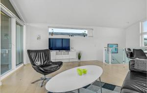 a living room with a couch and a table and a tv at Holiday Home Frederikshavn 03 in Frederikshavn