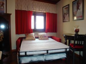 ロッカラーゾにあるAppartamento Roccaraso Aremognaのベッドルーム1室(赤いカーテンと窓付きのベッド1台付)