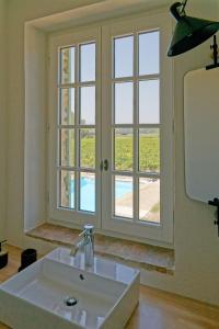 un bagno con lavandino e ampia finestra di Mastignac Chambre d'hôte a Valréas