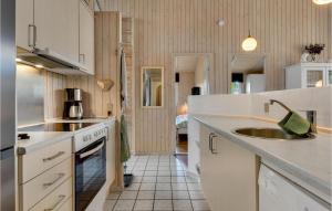 a kitchen with white cabinets and a sink at Holiday Home Sydals With Fireplace 1 in Sarup