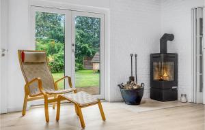 a living room with a chair and a fireplace at 4 Bedroom Lovely Home In Knebel in Knebel