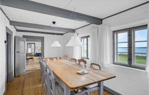 uma sala de jantar com uma mesa de madeira e cadeiras em Amazing Home In ster Assels With Kitchen em Øster Assels