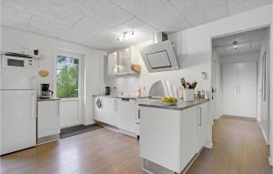 cocina con armarios blancos y suelo de madera en Four-Bedroom Holiday Home In Spottrup, en Spottrup 19 fotos más