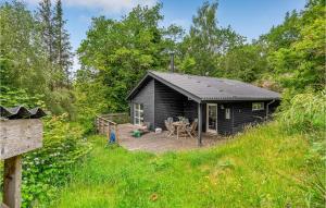 a black cabin in the woods with a wooden deck at Pet Friendly Home In Gistrup With Wifi in Gistrup