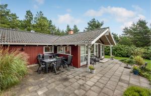 a house with a patio with a table and chairs at Three-Bedroom Holiday Home In Hurup Thy in Sindrup