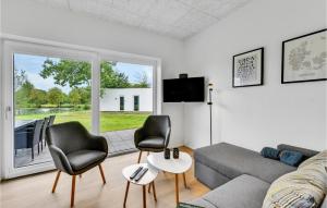 - un salon avec un canapé, des chaises et une fenêtre dans l'établissement 3 Bedroom Awesome Home In Ringkbing, à Ringkøbing
