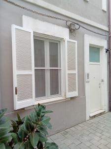 een huis met witte ramen en een deur bij Room 369 in Termoli