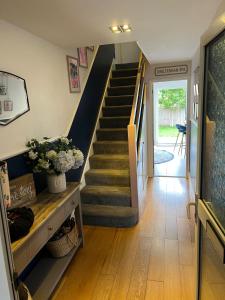 a hallway with a staircase and a stair case at Modern family home central Cheltenham in Cheltenham