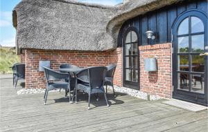 eine Terrasse mit Stühlen und einem Tisch auf einem Gebäude in der Unterkunft Three-Bedroom Holiday Home In Ringkobing in Ringkøbing + 23 Fotos
