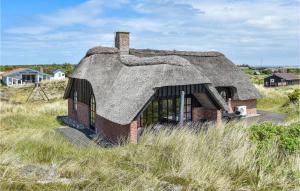 une maison ancienne avec un toit de chaume dans un champ dans l'établissement 3 Bedroom Beautiful Home In Ringkbing, à Ringkøbing