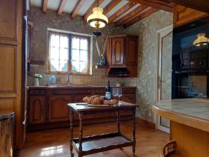una cocina con armarios de madera y una mesa con pan. en La Chasse - A Charming, Welcoming Gite In Normandy, en Anglesqueville-la-Bras-Long