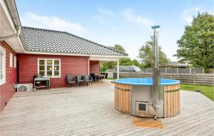 BroagerにあるBeautiful Home In Broager With 4 Bedrooms, Sauna And Wifiのホットタブと家のある裏庭
