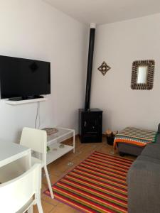 a living room with a flat screen tv on the wall at casita valdivia in Gaucín