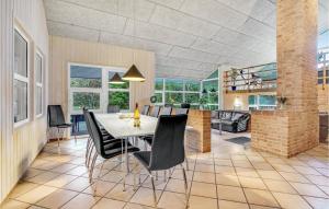 ein Esszimmer mit einem Tisch und schwarzen Stühlen in der Unterkunft Cozy Home In Hirtshals With Kitchen in Hirtshals